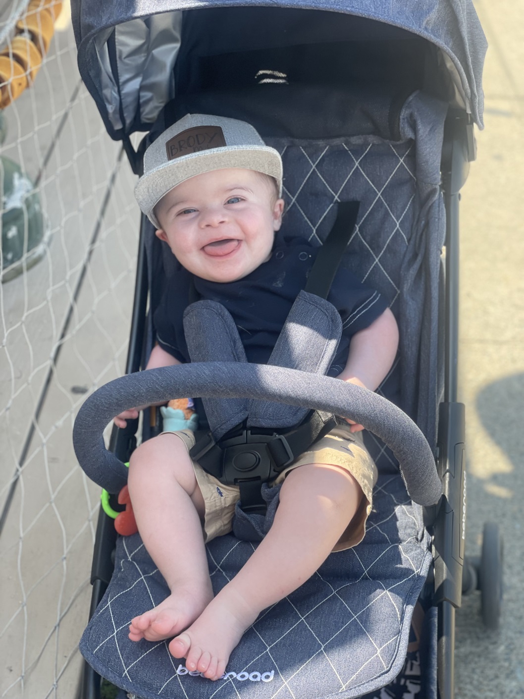 A baby boy smiling in his stroller
