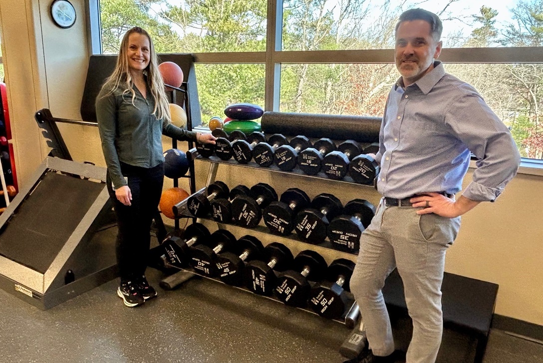 Two physical therapists standing by free weights at Physical Therapy and Wellness
