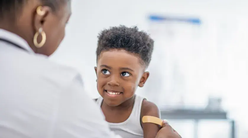 A young boy smiles after getting a vaccine