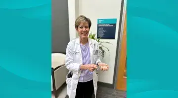 South Shore Health's Lisa Gould, MD, PhD poses for a photo holding a clear glass award.
