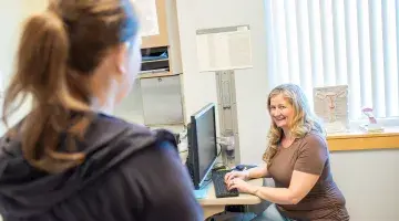 An OB/GYN provider at computer consulting with patient