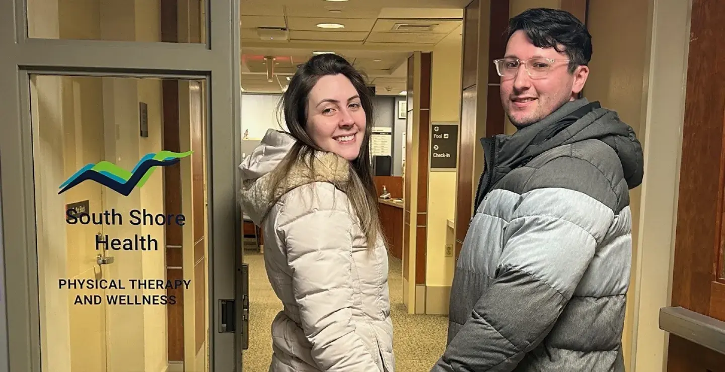 A woman and a man hold hands as they enter South Shore Health Physical Therapy and Wellness